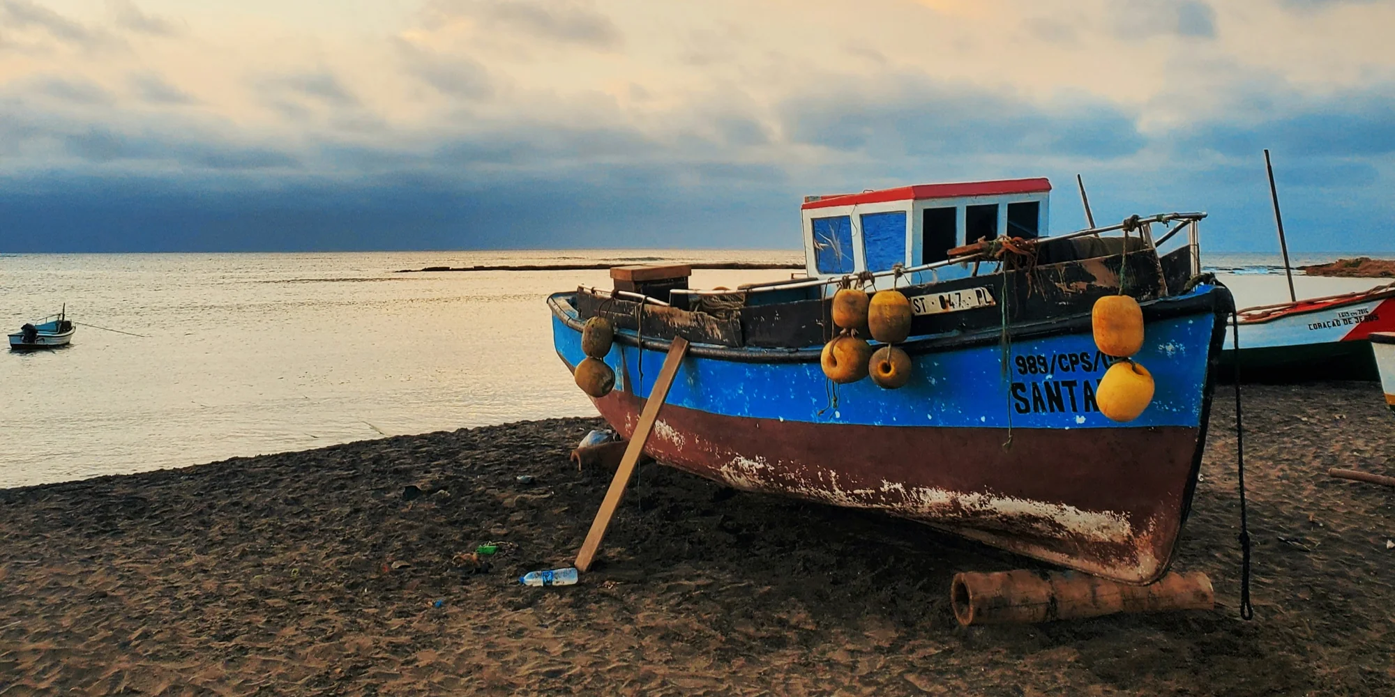Kap verde strand mit meerblick und kleinem blauen fischerboot haie tauchen