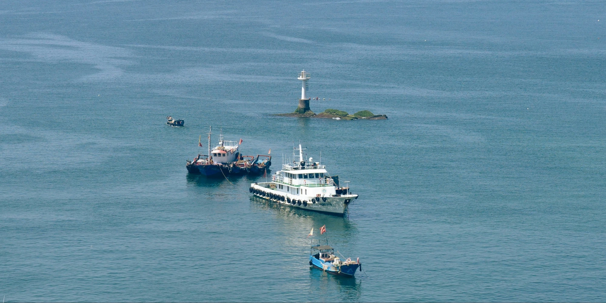 Boote neben einer kleinen Insel im Chinesischen Meer