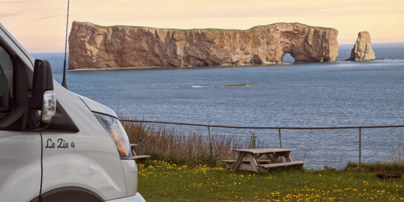Wohnmobil und Picknicktisch an der Küste mit Blick auf den Rocher Percé in Québec