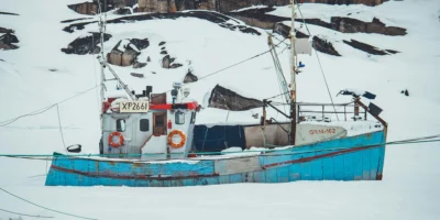 Fischerboot in einer verschneiten Polarlandschaft